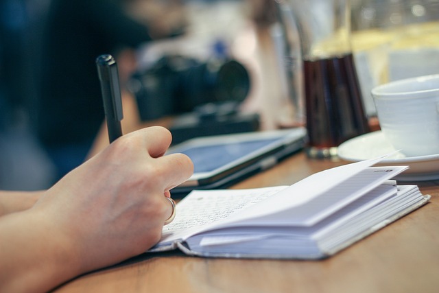 Photo d'une personne entrain d'écrire quelque chose dans un cahier de note